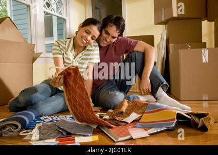 Hispanic couple looking at textile swatches in new house
