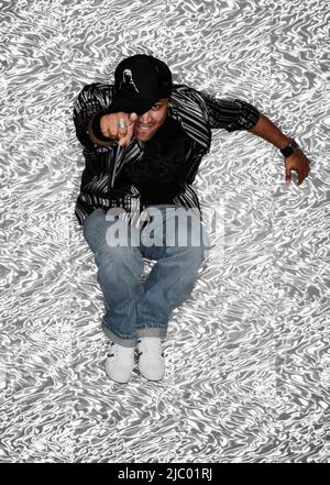 Hispanic man pointing and jumping Stock Photo