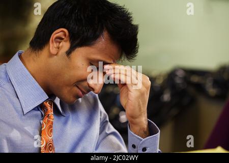 Businessman rubbing his forehead Stock Photo