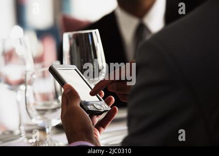 Businessman using a PDA in restaurant Stock Photo