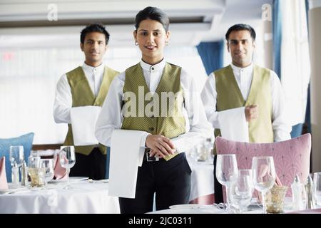 Waiters smiling for the camera in restaurant Stock Photo