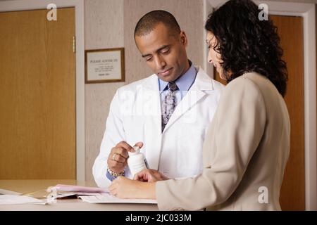 Doctors examining a bottle of pills Stock Photo