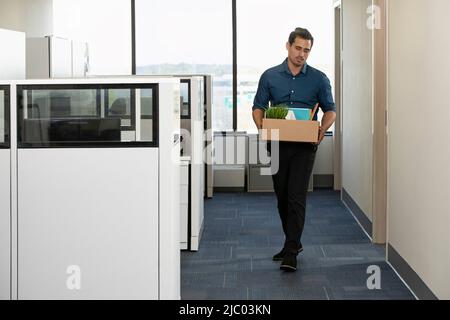A man walks out of his office with a box of his personal belongings Stock Photo
