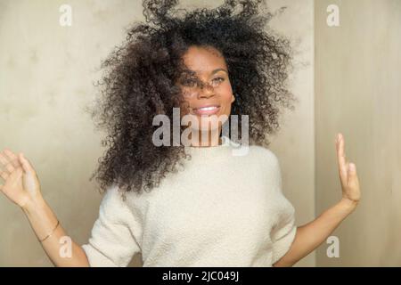 A middle aged woman throws her hands and hair around while dancing. Stock Photo