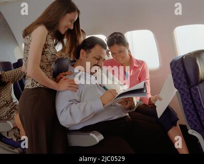 Mature man getting female attention on airplane Stock Photo