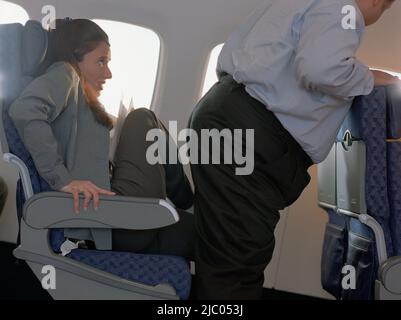 Overweight man squeezing by woman on airplane Stock Photo