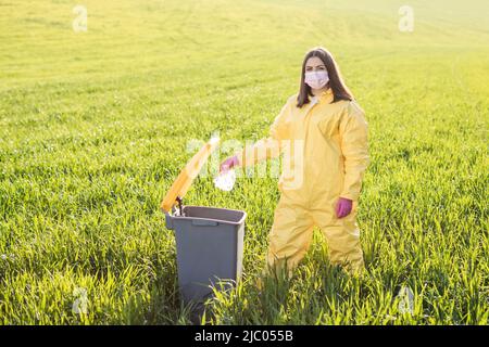 Hand throwing away plastic bottle in nature. Environmental damage by plastic waste.Environmental conservation Stock Photo