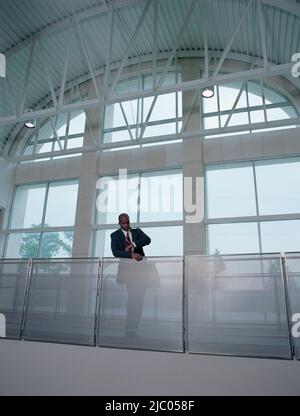 Businessman leaning on banister Stock Photo