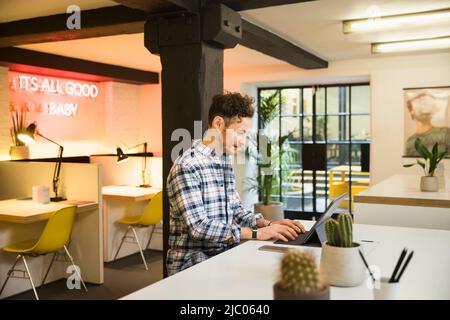 Young man in co-working space working on tablet Stock Photo