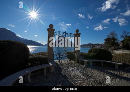 Gate on the Waterfront with Sunbeam and Alpine Lake Lugano with Mountain in Ticino, Switzerland. Stock Photo