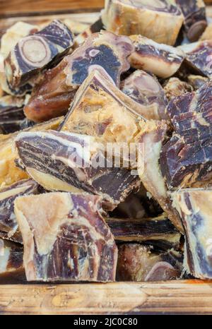 Iberian cured hambone displayed at street market stall. Selective focus Stock Photo