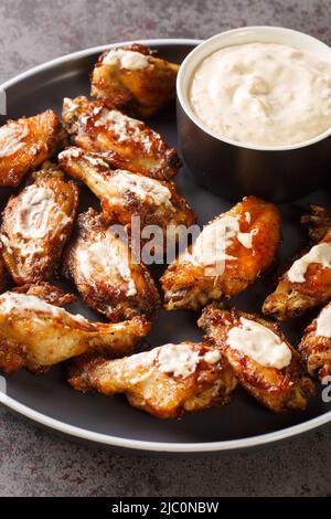 American Alabama White Sauce Chicken Wings closeup in the plate on the table. Vertical Stock Photo
