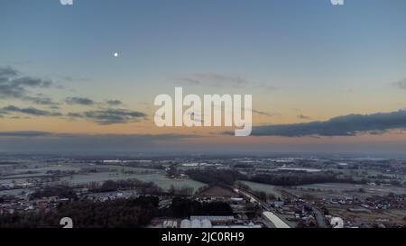 Rijkevorsel, Belgium, 28th of January, 2022, dramatic and colorful sunrise or sunset sky over the Little village of Sint Jozef, on the canal Dessel Schoten aerial photo in Rijkevorsel, kempen, Belgium, showing the waterway in the natural green agricultural landscape. High quality photo. High quality photo Stock Photo