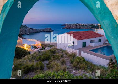 View of restaurant and whitewashed buildings at dusk in Arenal d'en Castell, Es Mercadal, Memorca, Balearic Islands, Spain, Europe Stock Photo
