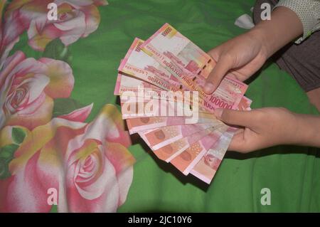 hand holding rupiah money and envelope isolated on white background ...
