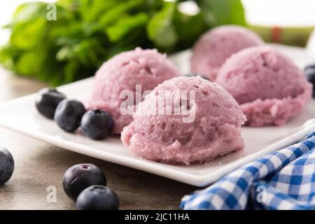 Blueberry ice cream scoops on wooden table Stock Photo
