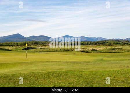 Golf course behind the sand dunes at Harlech beach with spectacular views of the mountains of Snowdonia, North Wales. Stock Photo