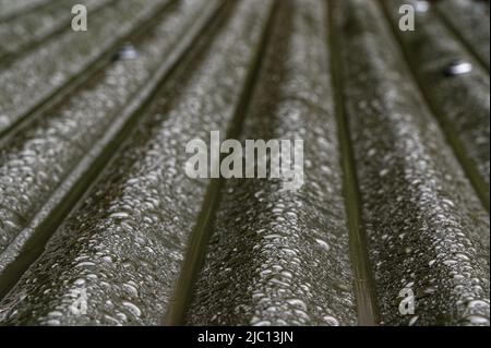 Corrugated iron channels the water down its troughs and off the roof. Stock Photo