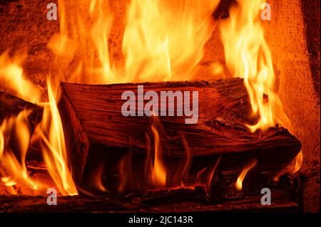 Winter warmth is generated from wood burning in an open fireplace. Stock Photo