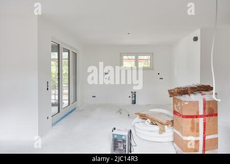 Open plan bright white eat-in kitchen after painting during home construction Stock Photo