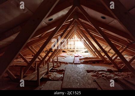 Undeveloped roof truss and attic from the house with wooden beams and insulating wool Stock Photo