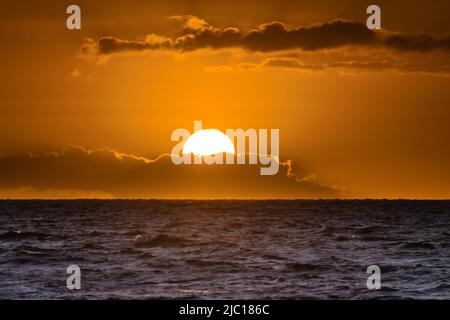 Sunset behind clouds over the sea at the Maalaea Bay, USA, Hawaii, Maui Stock Photo