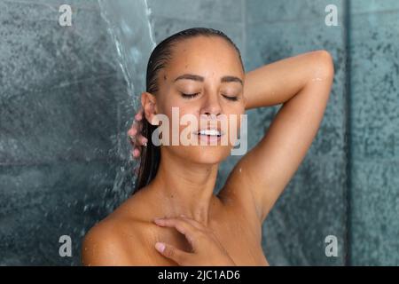 Close up of caucasian young woman taking a shower in the bathroom at home Stock Photo