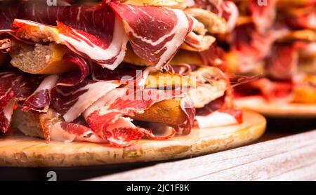 traditional Spanish bocadillos with Iberico jamon laid out in a slide on a shop window Stock Photo