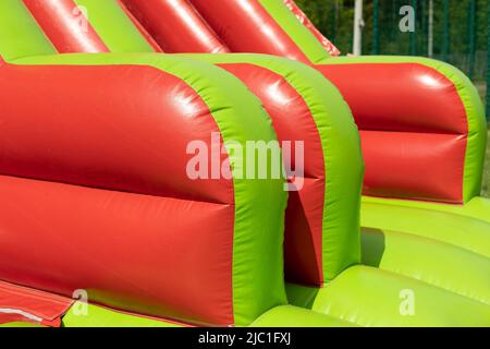 Red inflatable design. Inflatable slide. Obstacle course in amusement park. Stock Photo