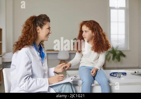 Cute little girl receives support from friendly female pediatrician during medical examination. Stock Photo