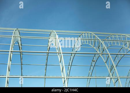 Basis for warehouse. Metal beams. Details of construction of sports complex. Steel details against blue sky. Stock Photo