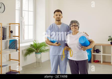 Smiling physiotherapist and aged patient in rehabilitation center Stock Photo