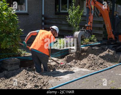 man digging a trench for the construction of fiber optic Stock Photo