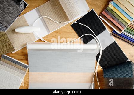 Samples of fabrics of different textures and colors in the form of a catalog for the selection of fabrics for fabric blinds. Samples of blinds day and Stock Photo