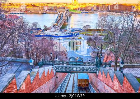 The running funicular cabin of historical Budapest funicular and panorama of Danube embankment of Pest side, Budapest, Hungary Stock Photo