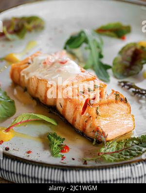 Baked salmon fillet steak with lemon and herbs Stock Photo