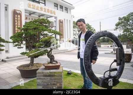 (220609) -- HANGZHOU, June 9, 2022 (Xinhua) -- A villager sells a potted landscape through livestreaming in Ningbo, east China's Zhejiang Province, May 19, 2022. In June 2021, China's central authorities issued a guideline on building Zhejiang into demonstration zone for achieving common prosperity. Under the guideline, the province will strive to achieve common prosperity by 2035, with its per capita gross domestic product and the income of urban and rural residents reaching the standard for developed countries. As an economic powerhouse in east China, Zhejiang Province has drawn up detai Stock Photo