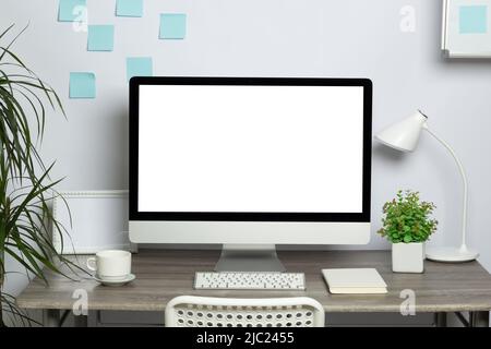 Modern computer with white screen and keyboard on stylish designer desktop. Freelancer workplace. Copy space, mock up. Stock Photo