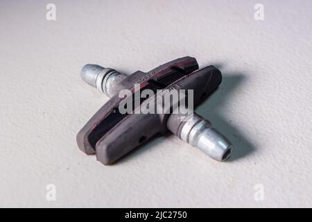 Old brake shoes for bicycle on a table. Brake shoes in an image are completely worn out, sooty and damaged. Stock Photo