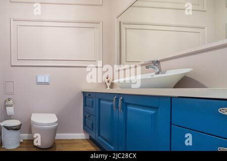 Interior of stylish bathroom room in modern house with white toilet bowl and wash basin.