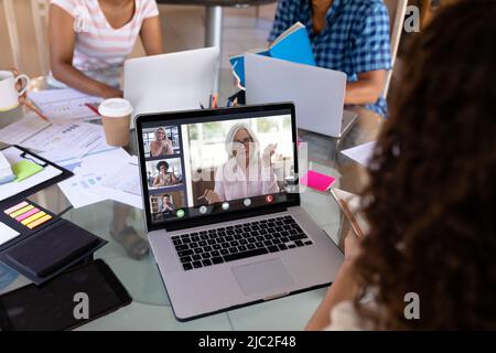 Multiracial business colleagues discussing work plan while having online meeting in office Stock Photo