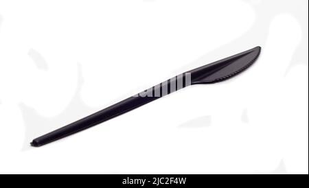 black plastic table knife on white background isolated closeup, disposable plastic tableware. Stock Photo