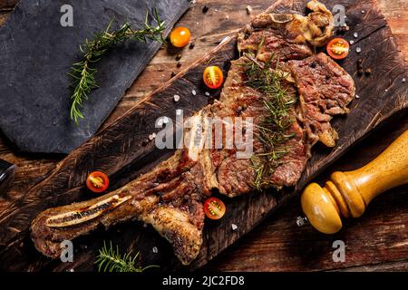 Tomahawk steak  on wooden with salt and black pepper,Garnish with rosemary.Top view,World food day Stock Photo