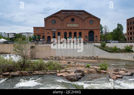 Denver, Colorado, May 28, 2022. Front View of the REI historical building, and Starbucks along the South Platter River Trail, from across the river Stock Photo