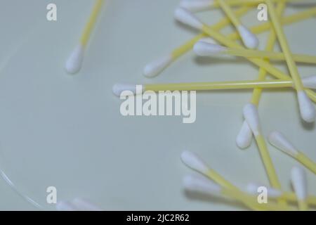 Yellow cotton swabs scattered on the surface. Stock Photo