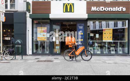 Ixelles, Brussels Capital Region - Belgium - 06 22 2020 Facade of Mc Donald's with a take away delivery boy Stock Photo