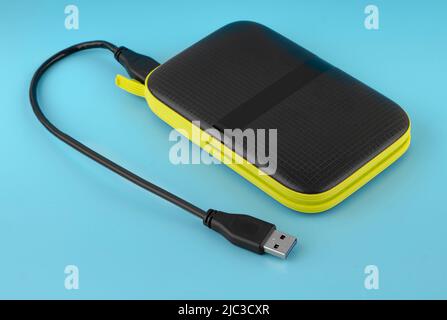 external hard drive, external drive with USB cable on a blue background Stock Photo