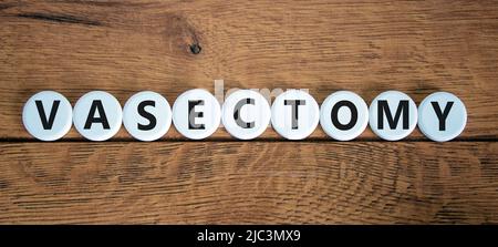 Vasectomy symbol. Concept words Vasectomy on white circles. Beautiful wooden table wooden background. Medical and vasectomy problem concept. Conceptua Stock Photo