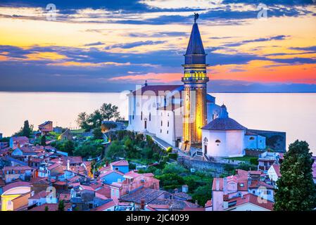 Piran, Slovenia. Panoramic view of Adriatic Sea and city of Piran in Istria, Saint George church night scene. Stock Photo