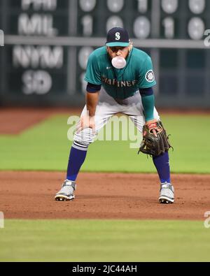 Seattle Mariners' Eugenio Suarez blows a bubble in the dugout